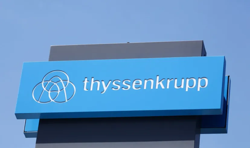 Thyssenkrupp-Logo auf blauem Schild vor klarem Himmel