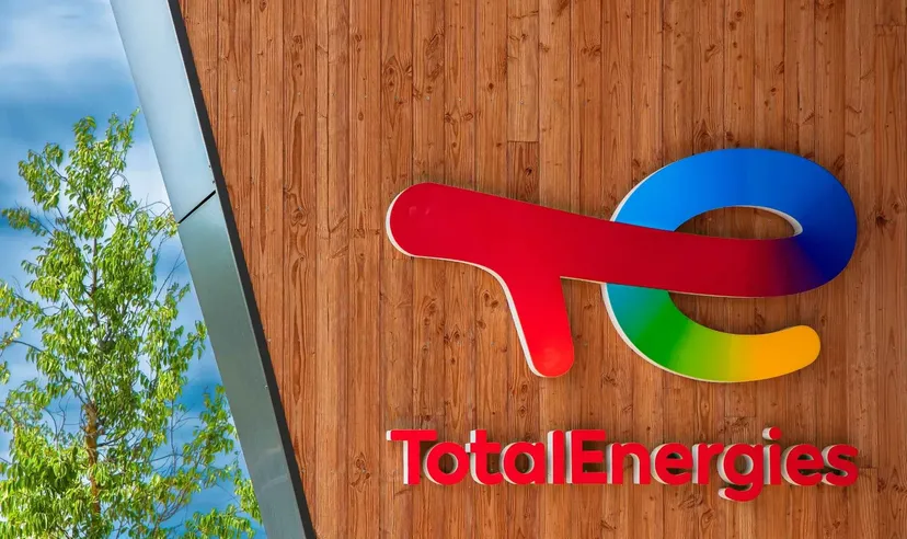 Logo TotalEnergies monté sur un mur en bois à l'extérieur d'un bâtiment