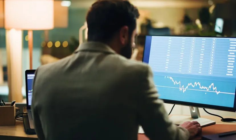 Mann analysiert Finanzdiagramme auf einem Computerbildschirm