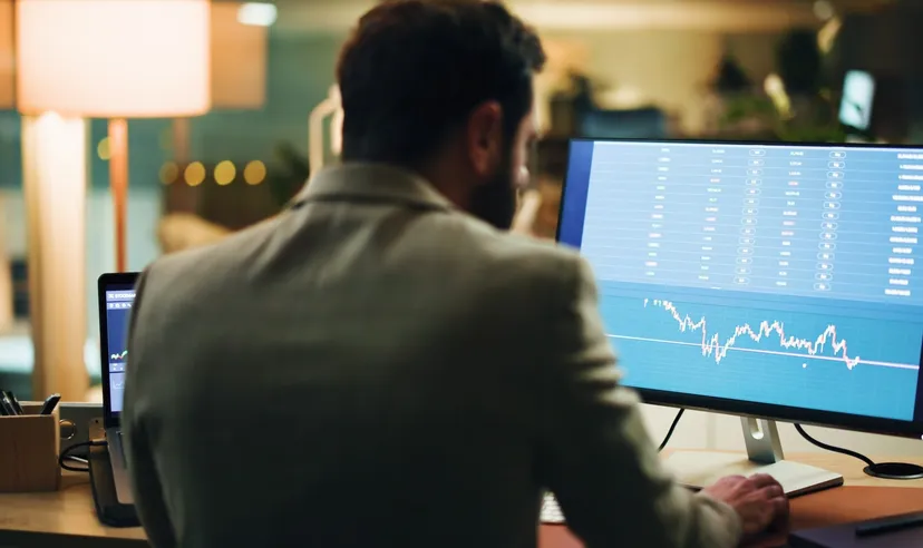 Man analyzing financial charts on a computer screen Man analyzing financial charts on a computer screen