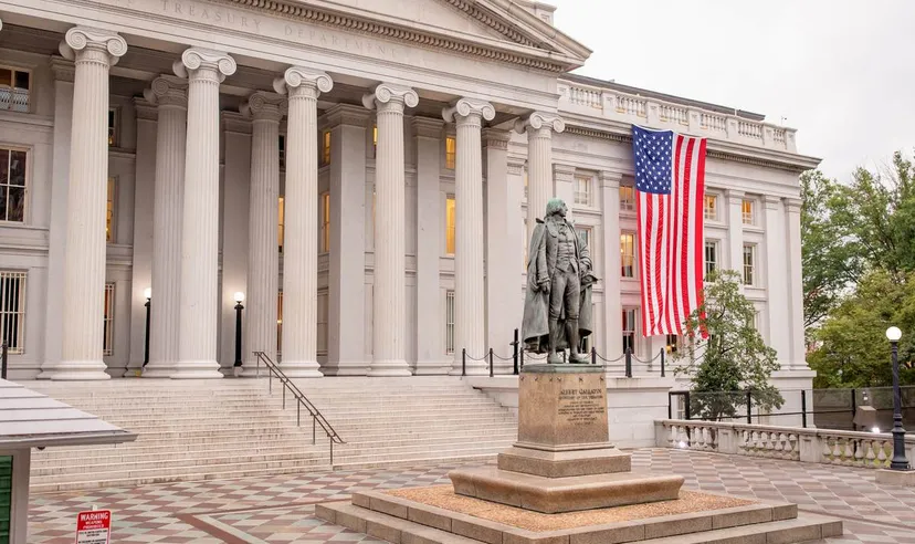 US Treasury Department building US Treasury Department building in Washington, DC, with its neoclassical columns, a large American flag on the facade and the Albert Gallatin statue in the forecourt