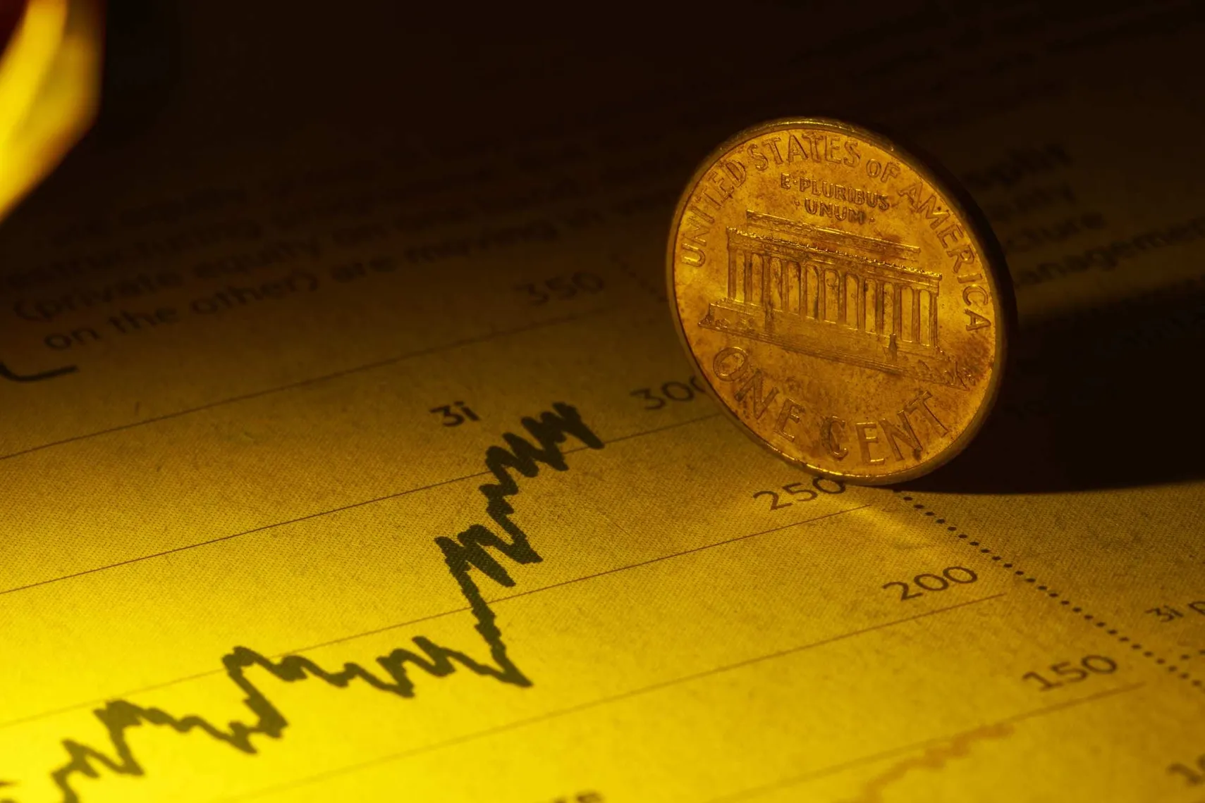 A US one-cent coin standing on a financial chart with an upward trend line, symbolizing market performance, investment growth, and economic trends. US one-cent coin on financial chart (Source: Shutterstock)
