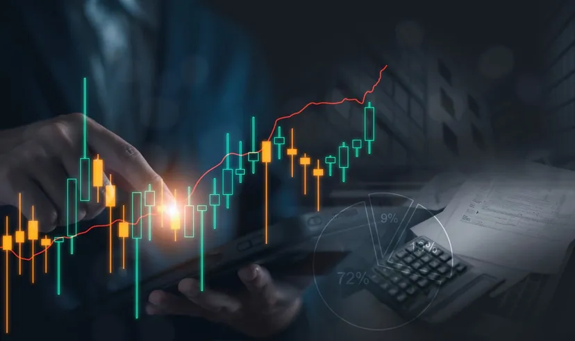 Hand interacting with a tablet displaying a rising candlestick chart and financial analytics, representing digital trading, investment analysis, and market performance. 